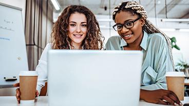 Two female colleague sharing a laptop